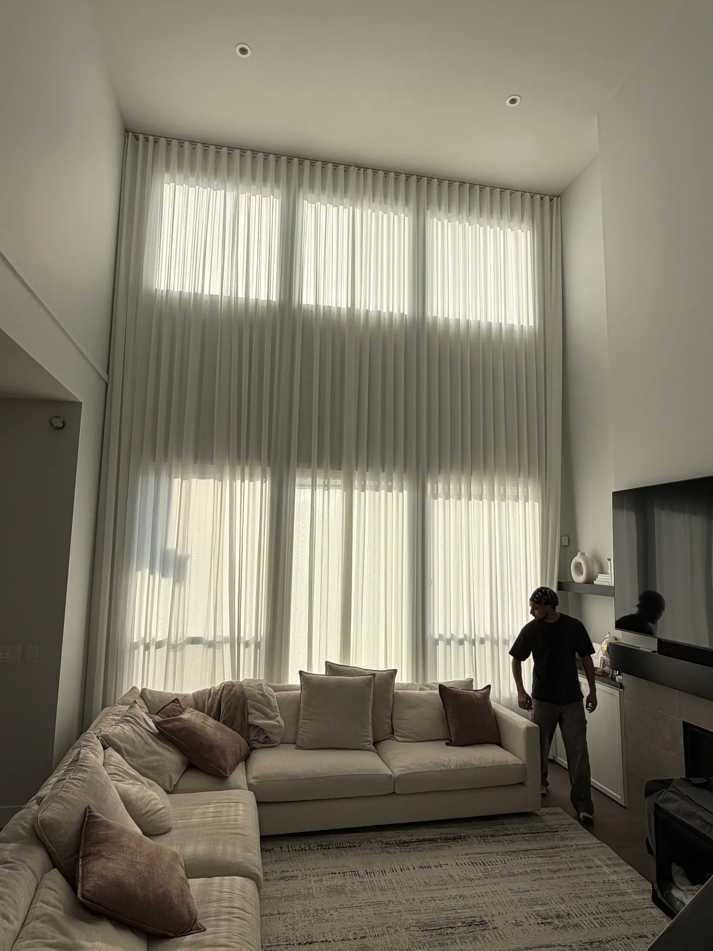 Sheer drapes installed across tall living room windows