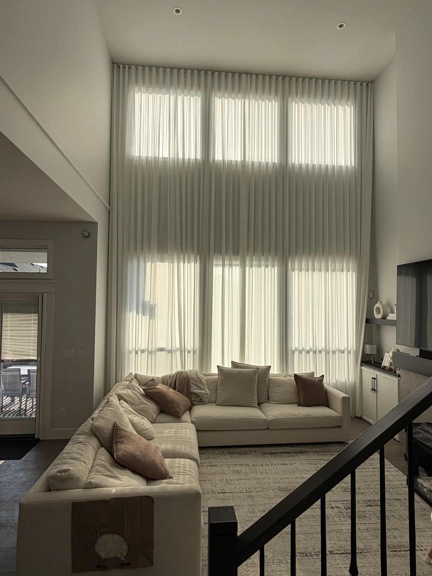 Full-height sheer drapes framing a bright modern living room