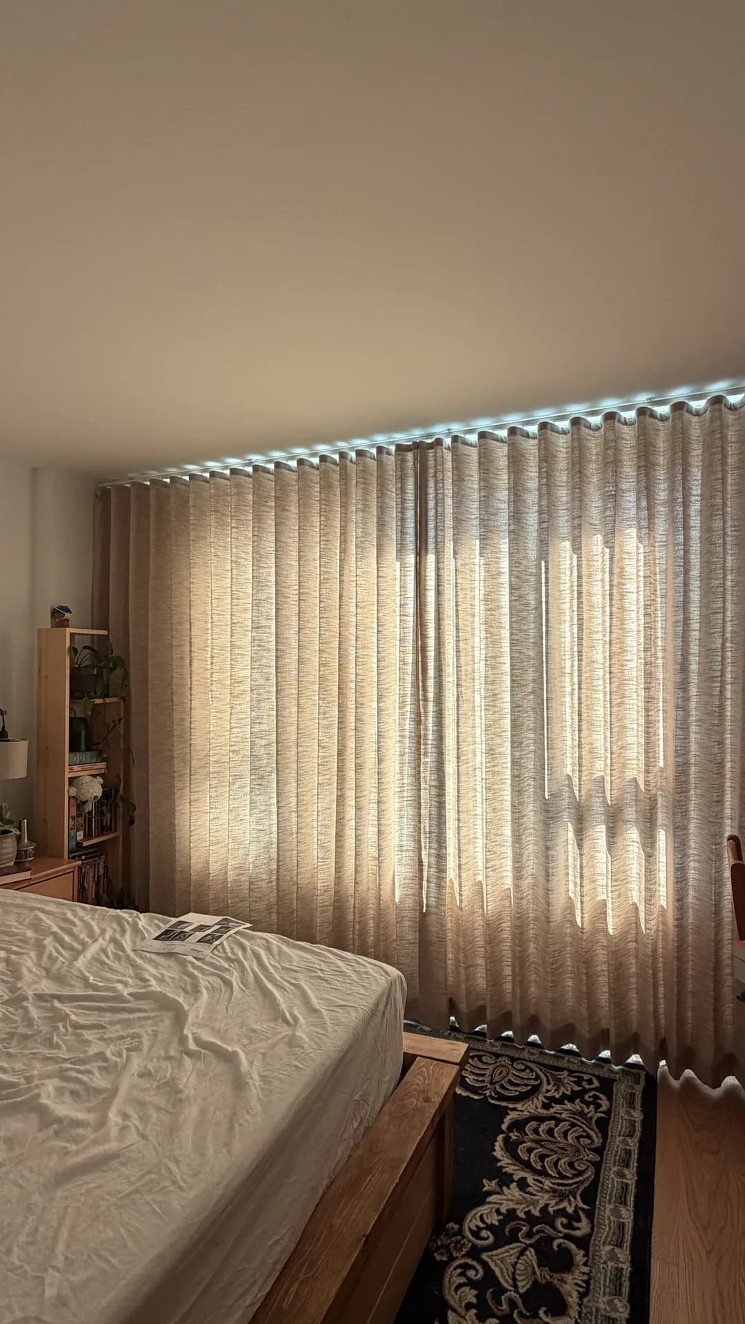 Floor-to-ceiling sheer curtains across a bedroom window