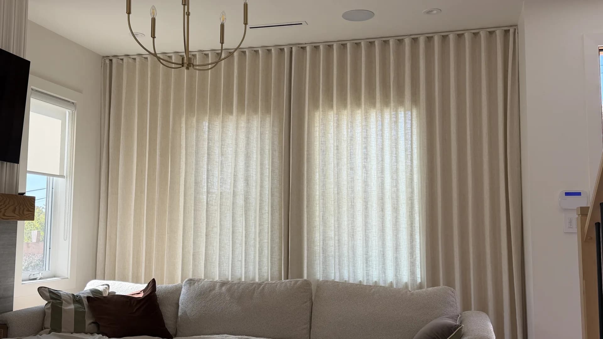 Floor-to-ceiling sheer curtains behind a living room sofa