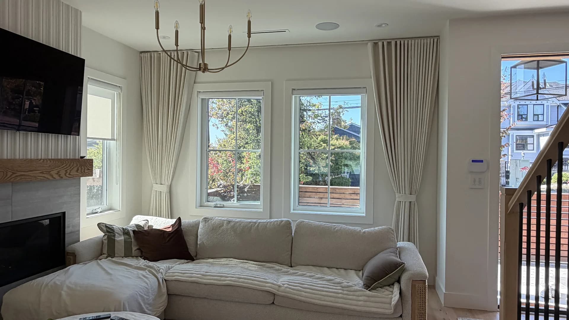 Living room windows framed by full-length sheer curtains