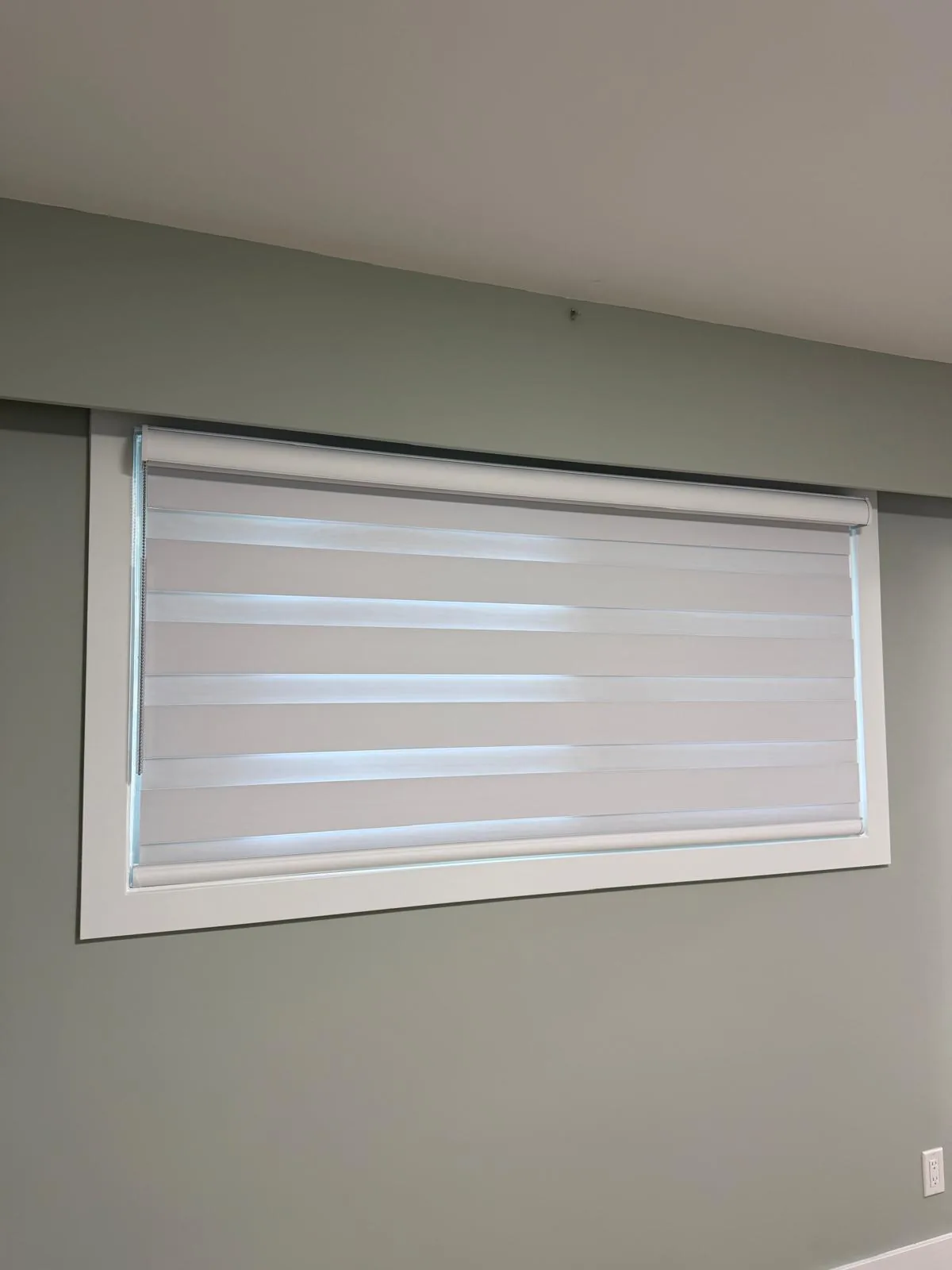 Layered zebra blind fitted over a wide window