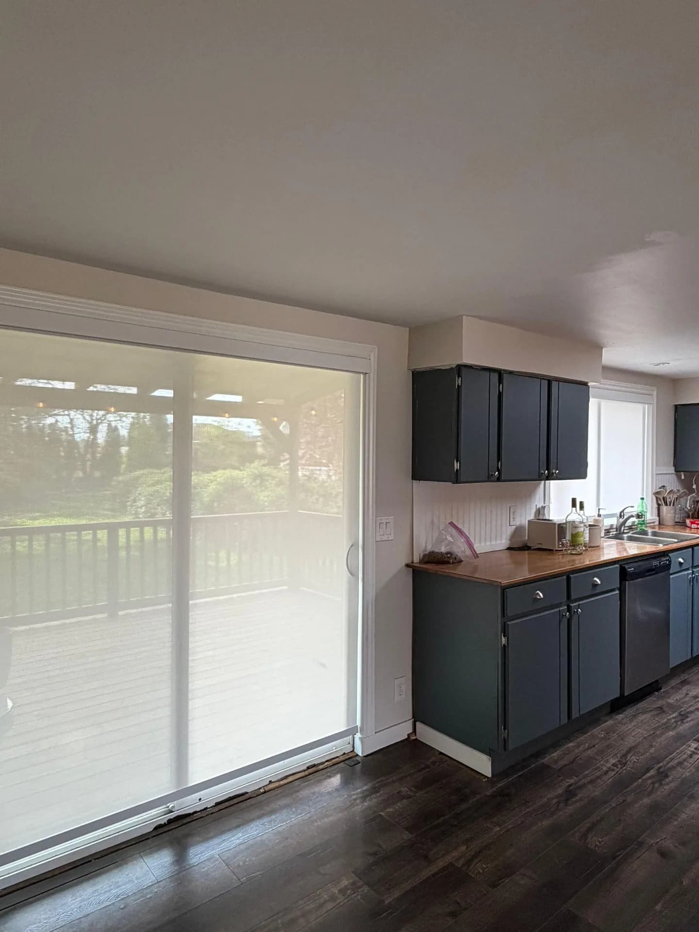 Light-filtering blinds over patio doors beside a kitchen
